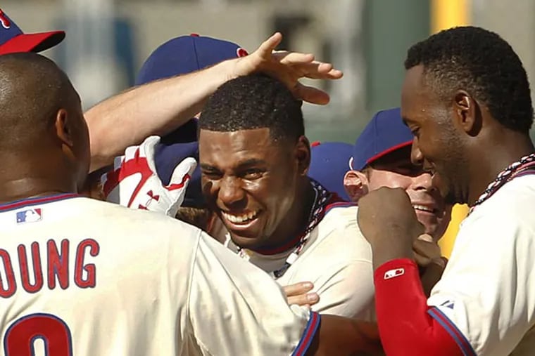 Phillies outfielder John Mayberry Jr. gets swarmed by teammates after driving in the winning run in the 10th inning against the White Sox on Sunday. (Ron Cortes/Staff Photographer)
