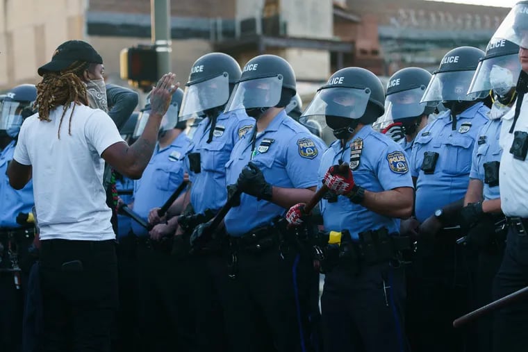 A protestor interacts with police at 52nd and Chestnut Streets, Sunday, May 31, 2020.