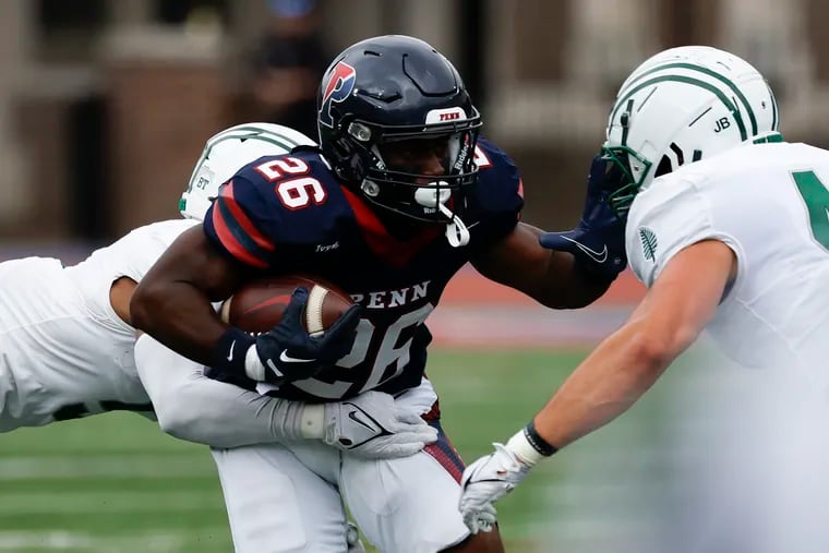 Penn wide receiver Issac Shabay (center) runs with the football against Dartmouth cornerback Tyson McCloud (left) and linebacker Macklin Ayers during a game at Franklin Field last month.