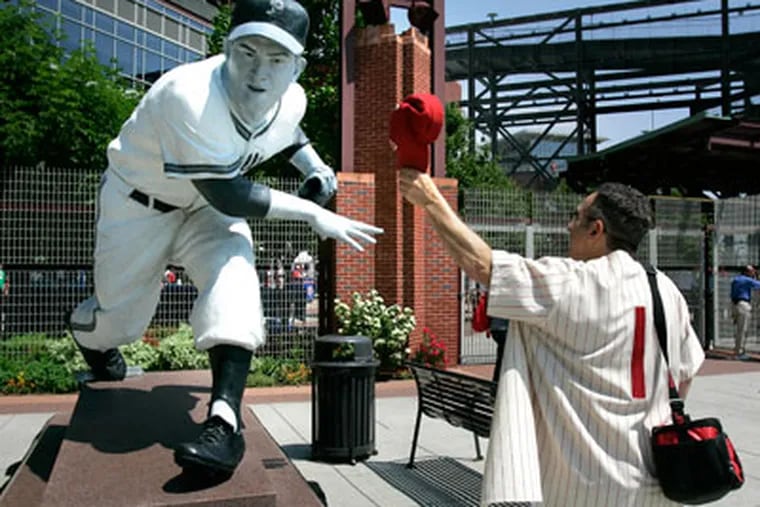 A fan tips his hat to a statue of Phillies pitcher Robin Roberts, who passed away today. (David Swanson / Staff Photographer)