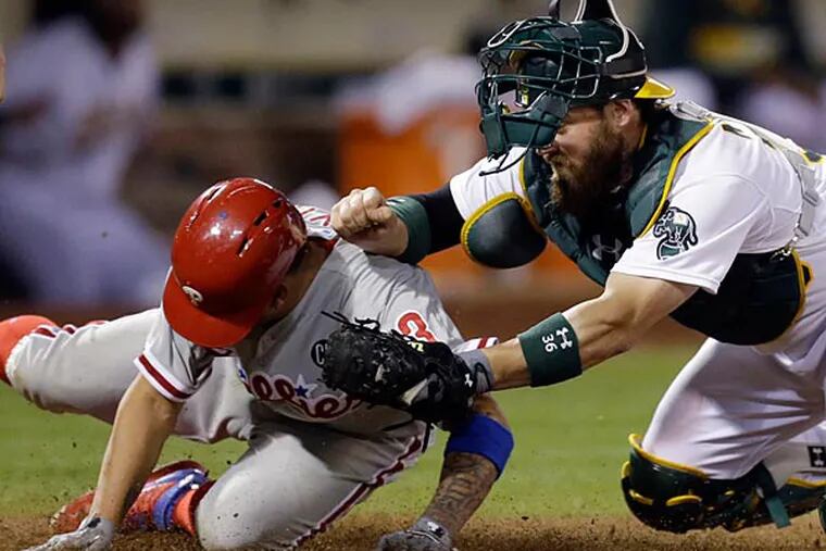 Oakland Athletics catcher Derek Norris, right, tags out Philadelphia Phillies' Freddy Galvis during the eighth inning of a baseball game Friday, Sept. 19, 2014, in Oakland, Calif. Galvis was attempting to score on a ball hit by Carlos Ruiz. (Ben Margot.AP)