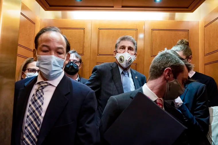 Sen. Joe Manchin (center), D-W.Va., and Sen. Kyrsten Sinema (far left), D-Ariz., board an elevator as they leave a meeting at the Capitol on Wednesday.