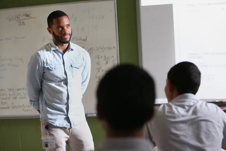Quamiir Trice, left, teaches a class at St. Gabriel's Hall. the disciplinary school he graduated from in 2011. Trice is leaving teaching after a rocky first year in the Philadelphia School District, he said.