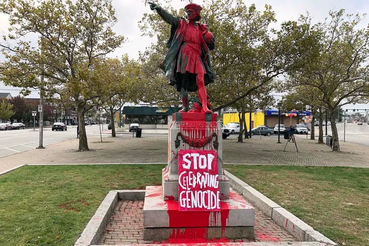A sign reading "stop celebrating genocide" sits at the base of a statue of Christopher Columbus on Monday, Oct. 14, 2019, in Providence, R.I., after it was vandalized with red paint on the day named to honor him as one of the first Europeans to reach the New World. The statue has been the target of vandals on Columbus Day in the past.