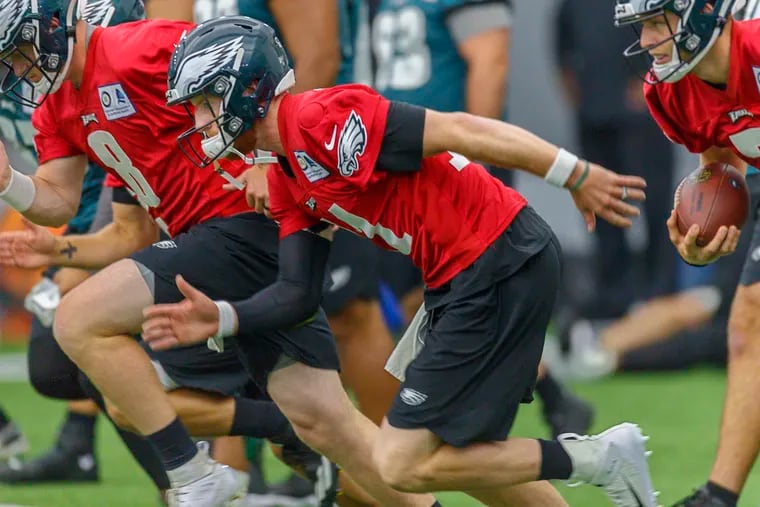 Eagles quarterback Carson Wentz (center) takes off in a sprint during warmups at the indoor practice facility on the last day of minicamp.