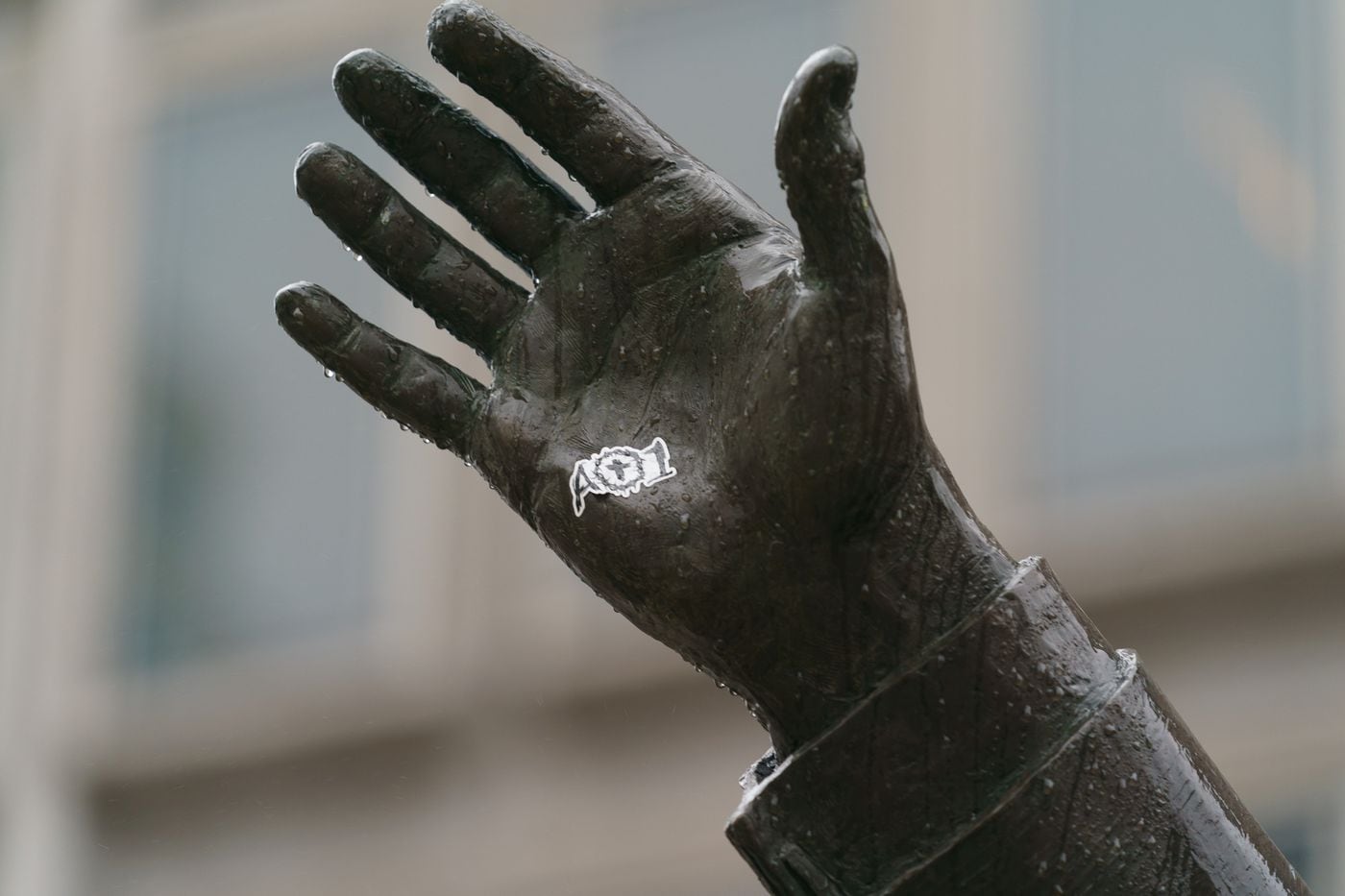 A sticker with the logo of Carson Wentz's AO1 Foundation was placed on the hand of the Frank Rizzo statue in front of the Municipal Services Building in Philadelphia.