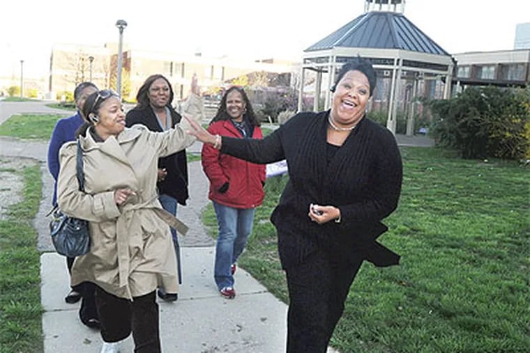 School Advisory Council members Valerie Johnson (left) and Conchevia Washington high-five each other outside King High School yesterday after Foundations, which the council opposed, withdrew. (Sarah J. Glover / Staff Photographer)