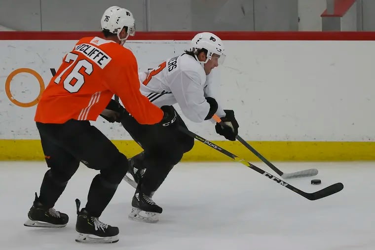 Flyers left winger Isaac Ratcliffe (left) defends teammate Elliot Desnoyers during development camp drills at the Flyers Skate Zone in Voorhees on Sunday.