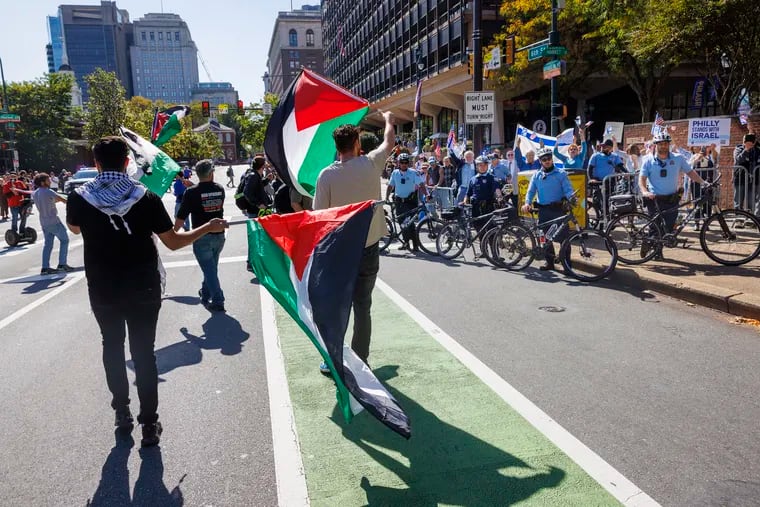 Palestinian Americans and supporters march down Sixth Street near Independence Hall Thursday protesting media coverage of the fighting between Israel and Hamas. At right are Philadelphia police surrounding supporters of Israel at the northwest corner of Market and North Sixth Streets.