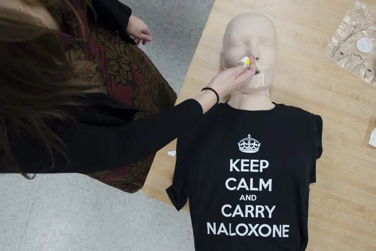 Harm Reduction Coordinator Allison Herens administers a Narcan nasal spray to a test dummy during an opioid public awareness campaign .