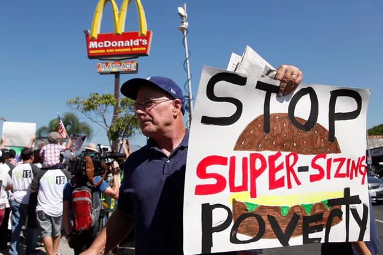 Kevin Cole protests outside a fast food restaurant on Thursday Aug. 29, 2013 in Los Angeles. Fast-food protests were under way Thursday in U.S. cities including New York, Chicago and Detroit, with organizers expecting the biggest national walkouts yet in a demand for higher wages. (AP Photo/Nick Ut)