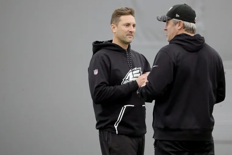 Eagles wide receivers coach Mike Groh, left, and head coach Doug Pederson, right, talk during a practice.