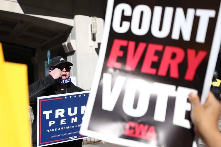 A Trump supporter faces off against "Count Every Vote" protesters outside the building where Philadelphia elections officials were counting votes in November 2020. Almost a year later, Pennsylvania Republican lawmakers are pursuing an investigation of the election.