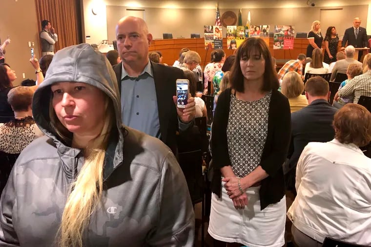 Anti-vaccination protestors Christie Nadzieja, front, Bob Runnells, back left, and Katie Bauer, back right, all of Vancouver, Washington, stand up and turn their backs on Gov. Jay Inslee on Friday, May 10, 2019, in Vancouver, Wash., as he signs a bill into law that eliminates personal belief and philosophical exemptions for the measles mumps and rubella vaccine for children who wish to attend school or day care.