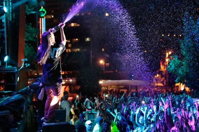 Steve Aoki sprays champagne on the crowd while performing on the Liberty Stage during the Budweiser Made in America Festival, on the Ben Franklin Parkway, in Philadelphia on August 30, 2014. ( ELIZABETH ROBERTSON / Staff Photographer )