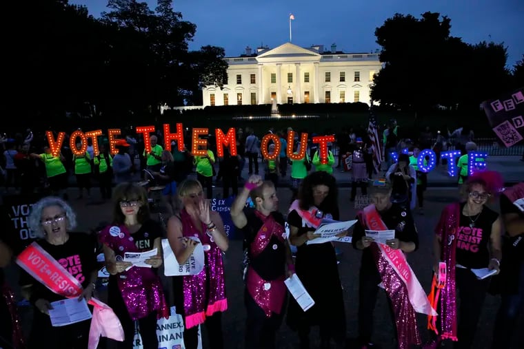 As dusk falls, groups including "Sing Out Louise" of New York City, front in pink, and Herndon Reston Indivisible, of northern Virginia, protest the confirmation of Brett Kavanaugh to the Supreme Court, Saturday, Oct. 6, 2018, outside of the White House in Washington.