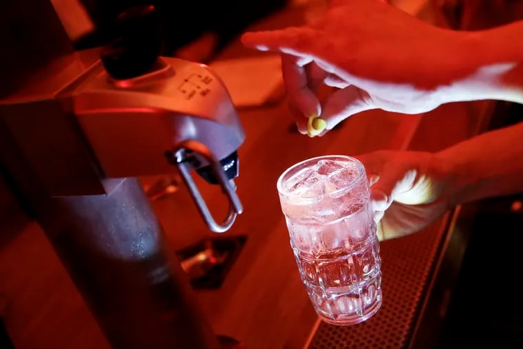 A Nunu bartender uses the whisky highball machine to make a highball twist on the Sazerac with absinthe and Peychaud’s.