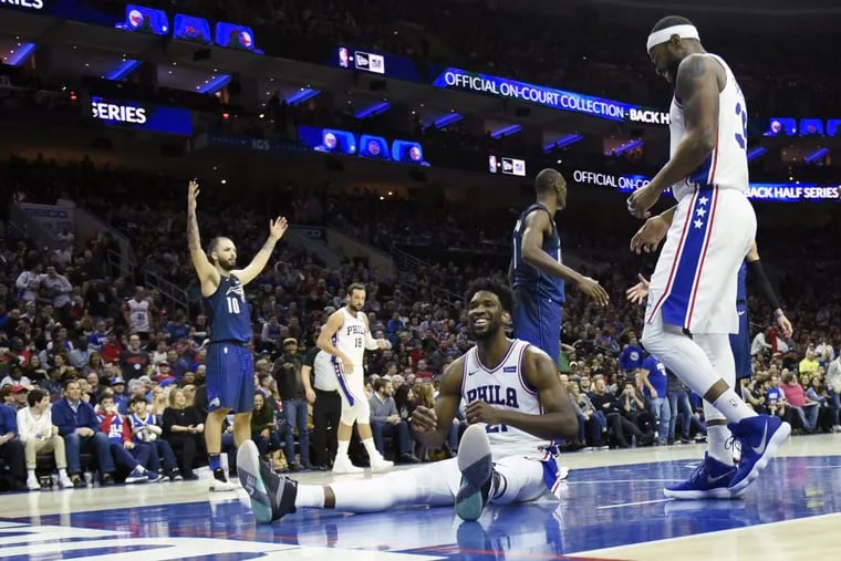 Sixers center Joel Embiid laughs after getting fouled on a dunk attempt during the Sixers’ win over the Magic on Saturday.