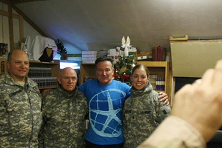 Comedian Robin Williams joins U.S. military personnel for photos.