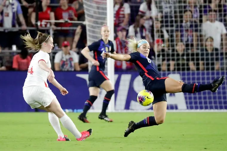 Julie Ertz (8) slides to block a pass by England's Kiera Walsh during last Thursday's game in Orlando, which was Ertz's 100th U.S. national team appearance.