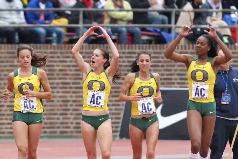 Oregon's team takes a victory lap after capturing the College Women's 4x800 Championship of America. Anchor Ann Kesselring makes an &quot;O&quot; with her arms.