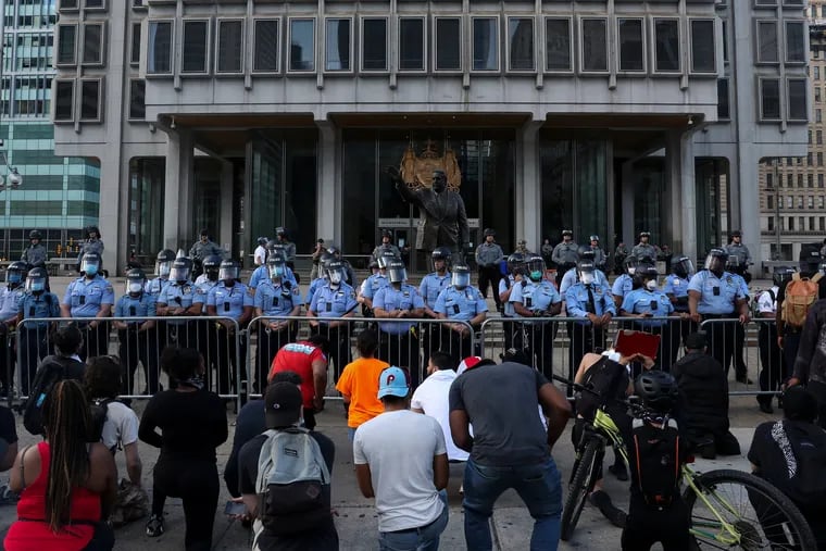 Police officers stand guard at the Municipal Services Building in Center City during a May 2020 protest following the murder of George Floyd.