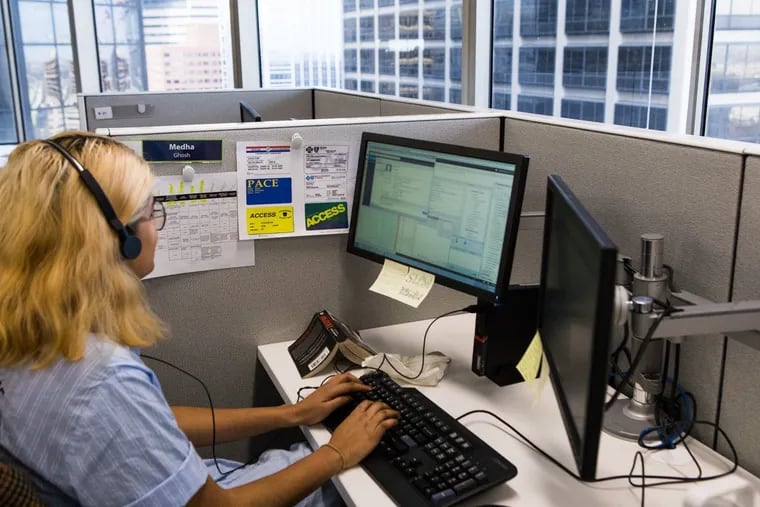 A Benefits Data Trust employee, shown here before the pandemic, helps a client with benefits access. The organization received a $20 million donation from MacKenzie Scott.