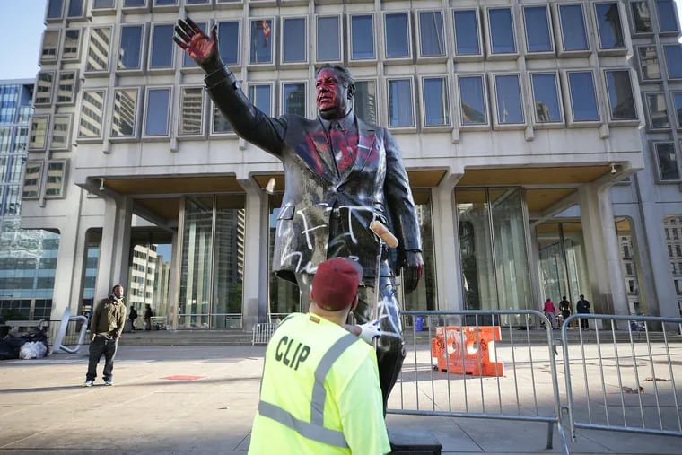 A workers removes paint from the Frank Rizzo statue as cleanup begins the day after protests in Philadelphia last Sunday.