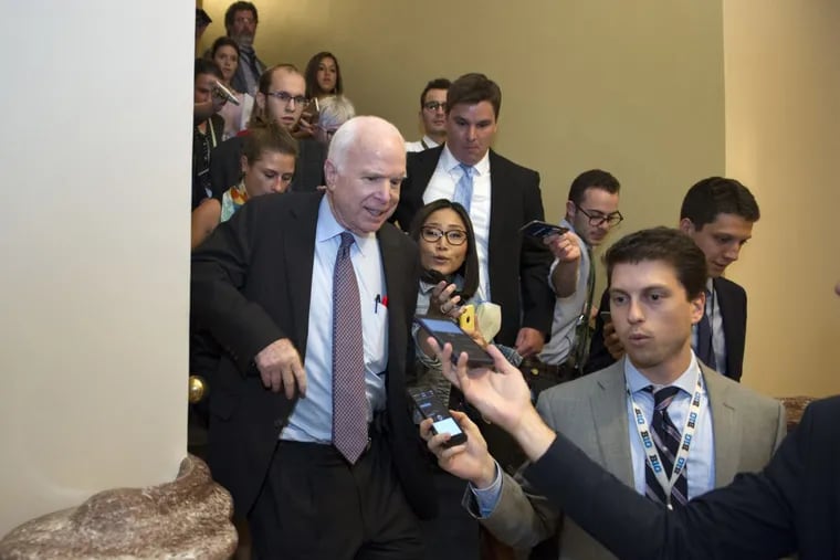Sen. John McCain is pursued by reporters after casting a vote against repealing the Affordable Care Act.