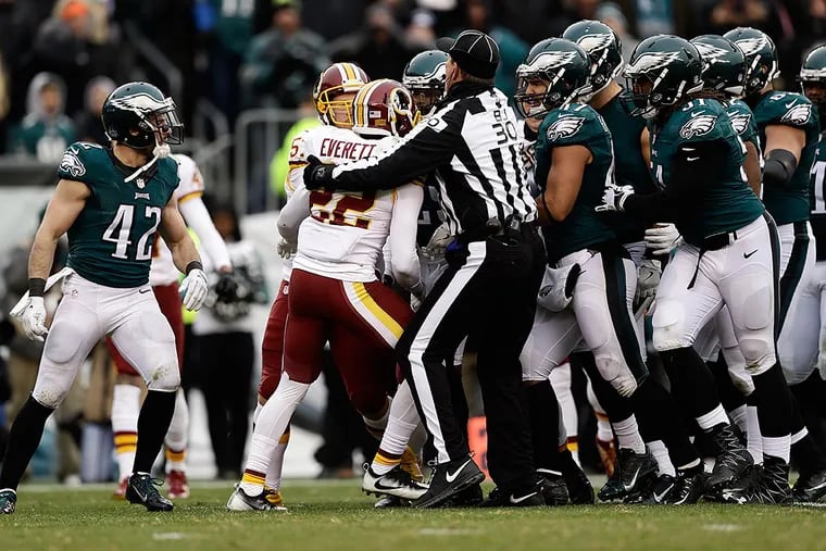 Washington Redskins' Deshazor Everett is held by an official after hitting Philadelphia Eagles' Darren Sproles during a punt in the second half of an NFL football game, Sunday, Dec. 11, 2016, in Philadelphia.