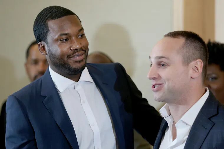 Rapper Meek Mill, left, greets his friend and Sixers co-owner Michael Rubin during a news conference promoting Gov. Tom Wolf's proposals to reform the criminal justice system at the National Constitution Center on Thursday, May 3, 2018. Wolf, Mill and several state legislators spoke in favor of reforms.