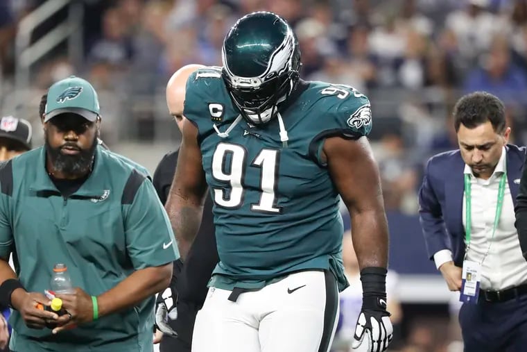 Eagles defensive tackle Fletcher Cox walks off the field after getting injured against Dallas on Monday night.