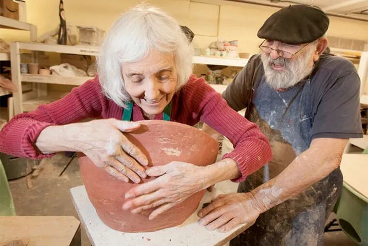 Carol Saler, left, works on a bowl with boyfriend and teacher Armand Mednick at the Allens Lane Art Center. (Ed Hille / Staff Photographer)