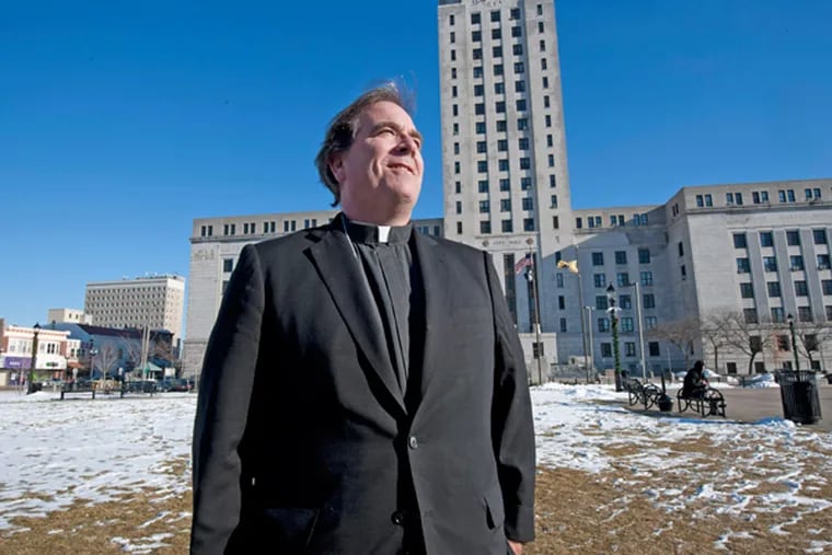 Father Jeff Putthoff in the field next to Camden City Hall where the field of crosses was planted in 2012. He was photographed on Dec. 13, 2013. (APRIL SAUL/Staff)