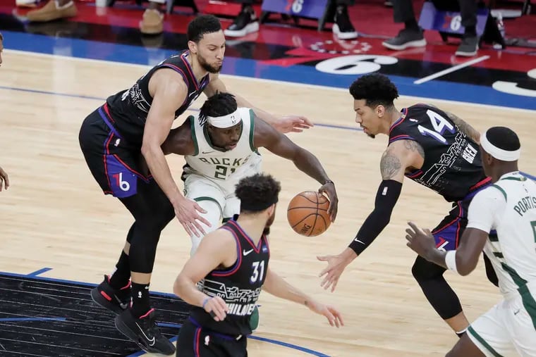 Sixers Ben Simmons and Danny Green defend against the Bucks' Jrue Holiday (21) in the second quarter of their game  at the Wells Fargo Center on Wednesday.