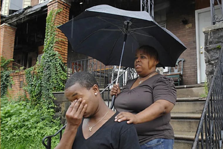 Donteze Savage, 19, and his mother, Robin Savage, at their house next to the shuttered store on North 50th Street, where, neighbors said, Latifa Savage, Donteze’s cousin and Robin’s niece, tangled with a cop on Saturday. (Alyssa Cwanger / Staff Photographer)