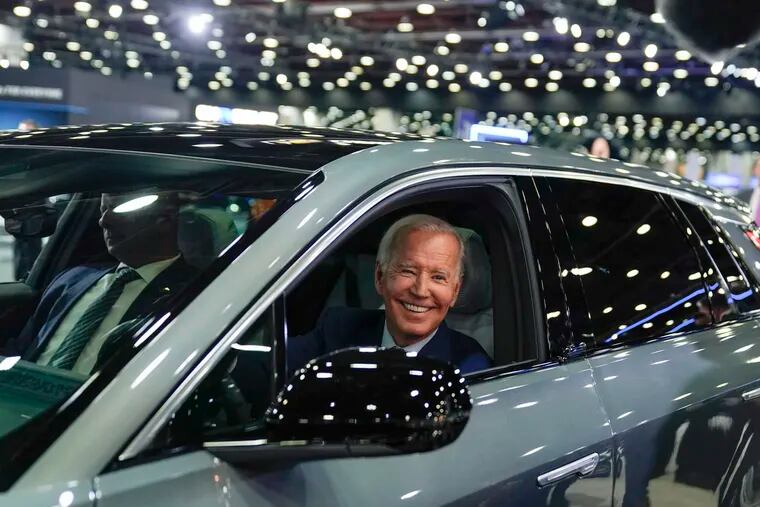 President Joe Biden drives a Cadillac Lyriq through the show room during a tour at the Detroit Auto Show in 2022 in Detroit.