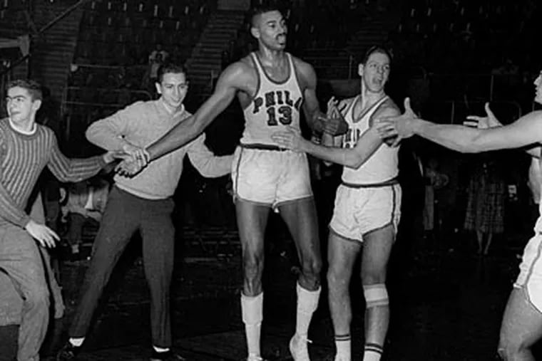 Fans and teammates surround Wilt Chamberlain to congratulate him after his 100-point game in 1962. (AP file photo)