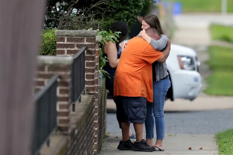 People embrace at the scene of an apparent shooting along the 4000 block of Meridian Street in Philadelphia, Pa. on August 17, 2018.