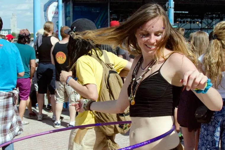 Emily Byllott gets a hula-hoop vibe going at the Jam on the River at Penn's Landing. Byllott, 22, from Long Island, teaches HoopYogini, a fitness program that combines hoops, modern dance, and yoga . &nbsp;&nbsp;&nbsp;RACHEL WISNIEWSKI / Staff Photographer