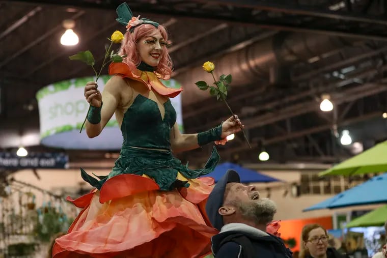 A performer on stilts walks around the 2020 Philadelphia Flower Show inside the Pennsylvania Convention Center on its opening day, Saturday. The show will be open until next Sunday, March 8. This year's theme is “Riviera Holiday."
