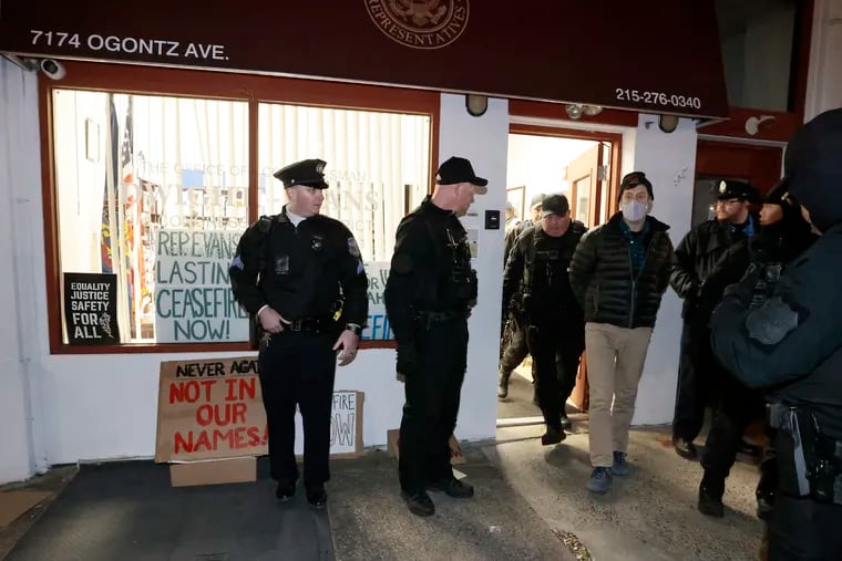 Police take into custody individuals who were involved in a sit-in demonstration at Rep. Dwight Evans office on Ogontz Avenue in Philadelphia Friday.