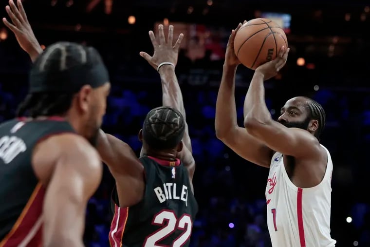 Miami’s Jimmy Butler tries to block a shot by Sixers James Harden.