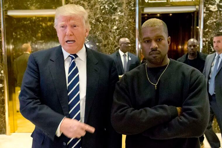 President-elect Donald Trump poses with rapper Kanye West for a picture in the lobby of Trump Tower in New York. It wasn't immediately clear what they discussed Tuesday morning. &quot;We've been friends for a long time,&quot; Trump told reporters. West only smiled when asked about the possibility of performing at Trump's inauguration.