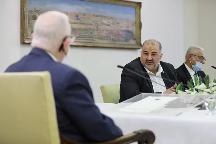Israeli Arab politician, leader of the United Arab list, Mansour Abbas (center) discusses with President Reuven Rivlin (left) on who might form the next coalition government, at the president's residence in Jerusalem on April 5, 2021.