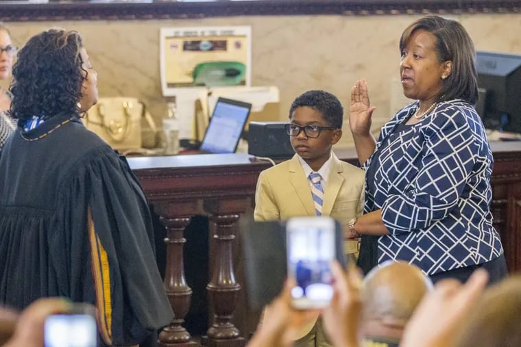 Kelley Hodge (right) being sworn in as interim Philadelphia District Attorney by Judge Sheila Woods-Skipper. Hodge’s son, Grant, held the Bible at the July ceremony.