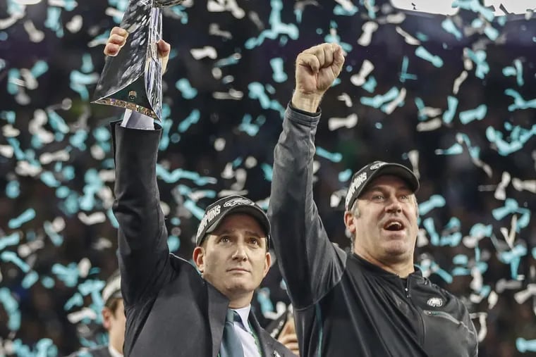 Eagles vice president Howie Roseman, left, and head coach Doug Pederson, right, celebrating on the victory platform with the Lombardi Trophy at the Super Bowl, in Minneapolis.
