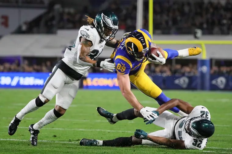 Rams tight end Tyler Higbee gets taken down by Eagles cornerbacks Cre'von LeBlanc (left) and Rasul Douglas during the first quarter.