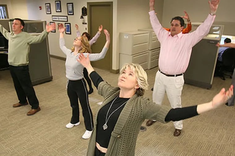 Charon Planning is a small company that provides some unusual perks to workers, including T'ai Chi classes and on-site massages. Christina Carter, center, and other employees take part in a T'ai Chi class. (Charles Fox / Staff Photographer)