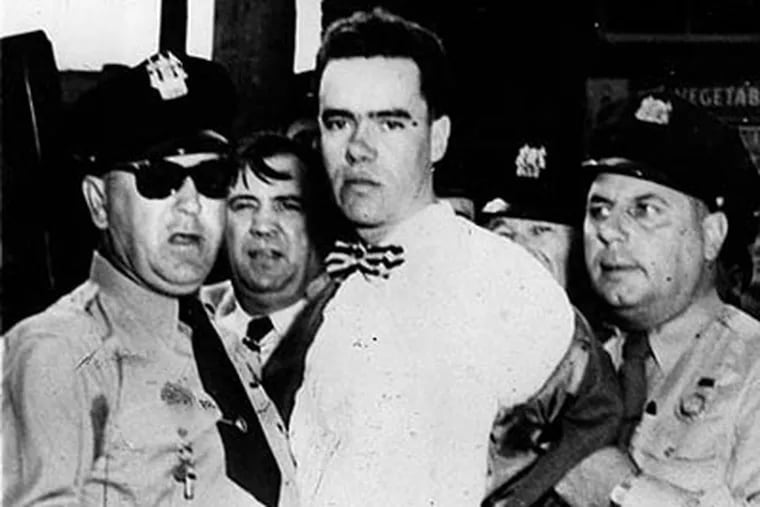 Howard Unruh is held by police after his shooting rampage, killing 12 people in 1949.